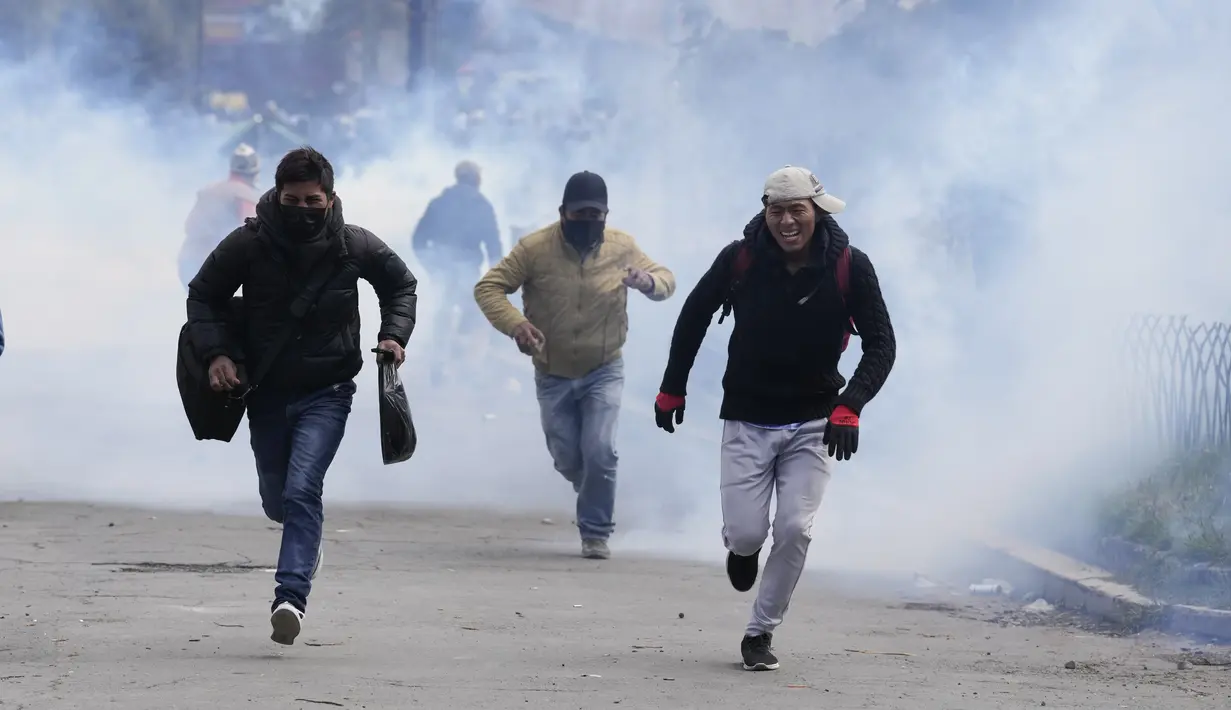 Petani koka anti-pemerintah melarikan diri dari gas air mata yang ditembakkan oleh polisi anti huru hara di dekat pasar koka di La Paz, Bolivia, Kamis (23/9/2021). (AP Photo/Juan Karita)