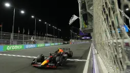 Pebalap Red Bull, Sergio Perez melewati garis finish saat Formula 1 GP Arab Saudi 2023 yang berlangsung di Jeddah Corniche Circuit, Senin (20/03/2023) WIB. (AP Photo/Pool/Luca Bruno)