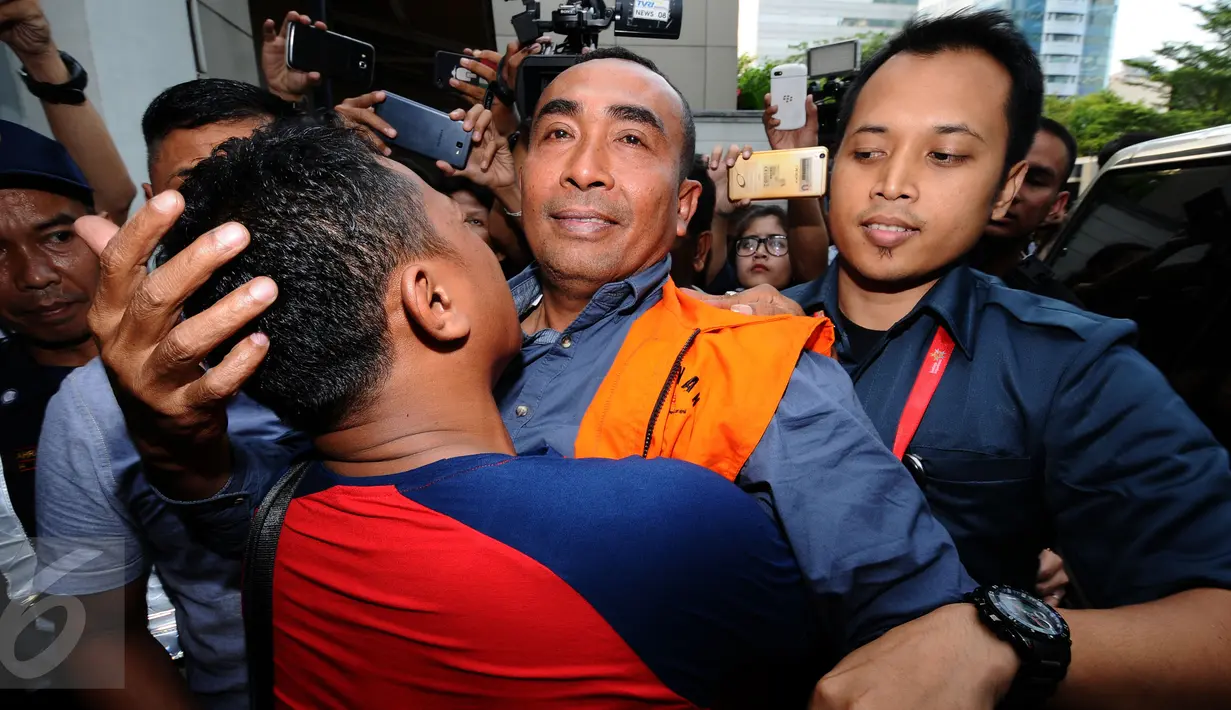 Bupati Buton nonaktif, Samsu Umar Abdul Samiun dipeluk kerabatnya usai menjalani pemeriksaan di Gedung KPK, Jakarta, Kamis (26/1). Samsu Umar tersangka dugaan suap Ketua Mahkamah Konstitusi Akil Mochtar, Oktober 2016. (Liputan6.com/Helmi Fithriansyah)