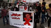 Pengunjuk rasa memegang poster yang menunjukkan Perdana Menteri Irak yang ditunjuk Mohammed Tawfiq Allawi dengan bahasa Arab yang berbunyi, "Ditolak atas perintah rakyat," dalam sebuah rapat umum di Baghdad, Irak, Minggu, 1 Maret 2020. (AP Photo/Khalid Mohammed)
