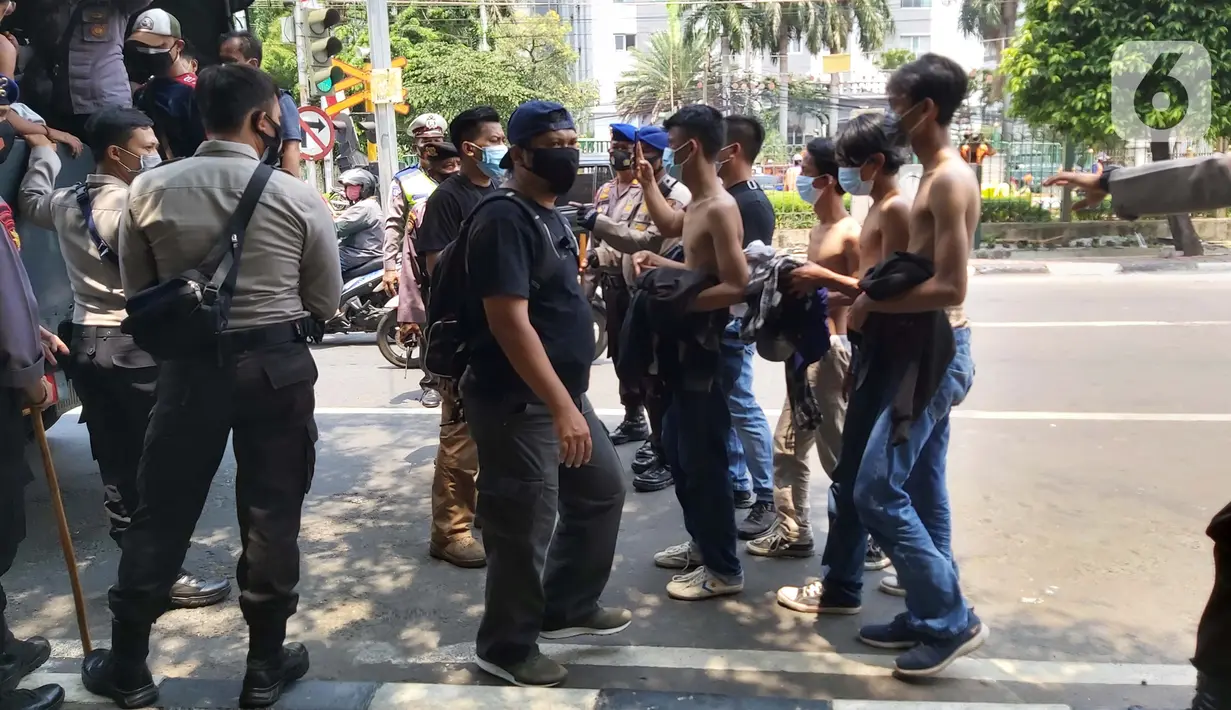 Sejumlah remaja diamankan aparat kepolisian saat berkumpul di Kawasan Palmerah, Jakarta, Kamis (8/10/2020). Dari hasil pemeriksaan, mereka turun ke jalan karena mendapatkan undangan dari media sosial untuk melaksanakan aksi unjuk rasa di sekitar DPR. (Liputan6.com/Faizal Fanani)