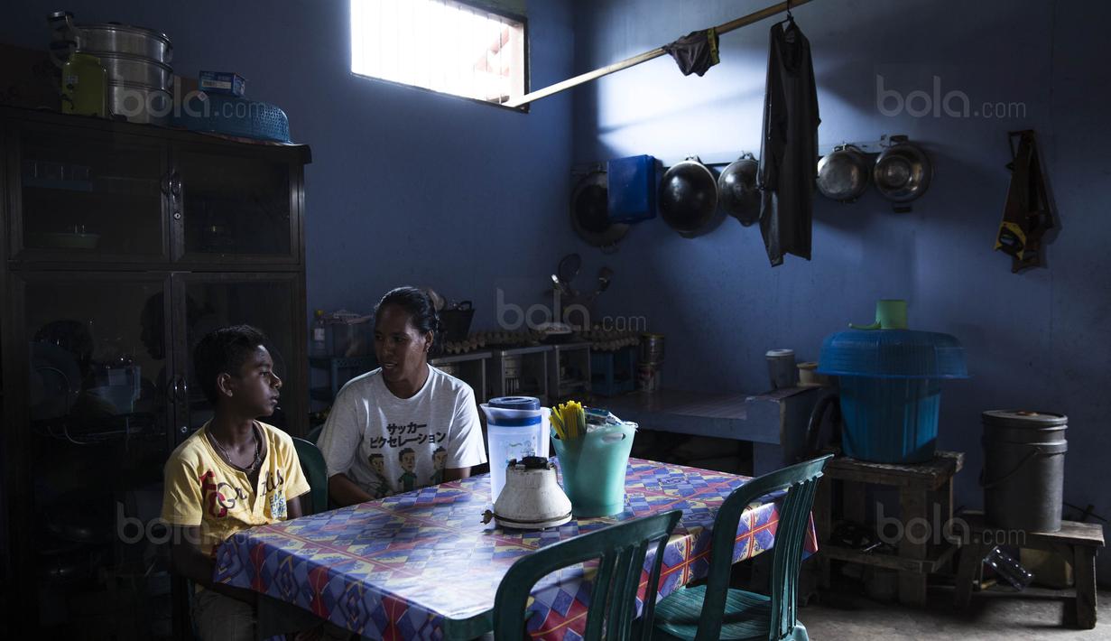 Pesepak bola SSB Tulehu Putra, Alghy Nahumarury, bersama sang ibunda Nurleila, Umarella, di rumahnya di Tulehu, Maluku, Selasa (15/11/2017). Setiap pulang sekolah Alghy selalu membantu ibunya bekerja. (Bola.com/Vitalis Yogi Trisna)