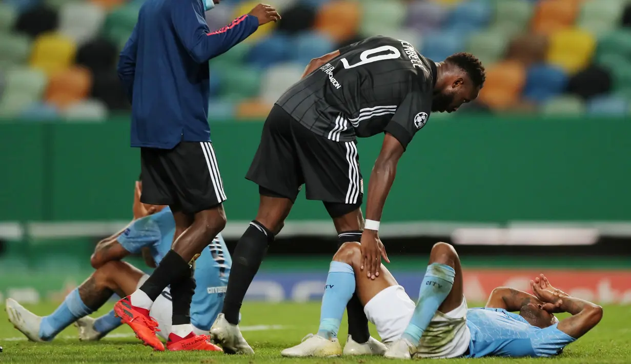 Pemain Lyon, Moussa Dembele, berusaha menguatkan striker Manchester City, Raheem Sterling, usai ditaklukkan pada perempat final Liga Champions di Stadion Jose Alvalade, Sabtu (15/8/2020). Lyon menang 3-1 atas Manchester City. (Miguel A. Lopes/Pool via AFP)