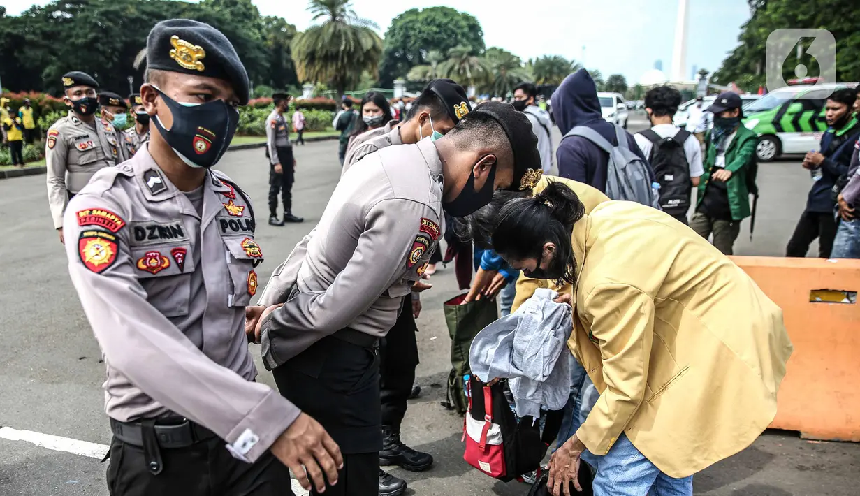 Polisi memeriksa barang bawaan mahasiswa yang akan berunjuk rasa di Patung Kuda, Jakarta, Selasa (20/10/2020). Pemeriksaan tersebut dilakukan untuk memastikan unjuk rasa berjalan aman dan damai. (Liputan6.com/Faizal Fanani)