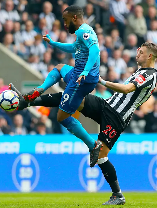 Penyerang Arsenal, Alexandre Lacazette berusaha mengontrol bola dari kawalan pemain Newcastle United, Florian Lejeune pada lanjutan Liga Inggris di St James 'Park, (15/4). Newcastle menang atas Arsenal 2-1. (Owen Humphreys/PA via AP)