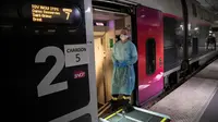 Petugas medis berdiri di pintu masuk kereta kecepatan tinggi TGV di Stasiun Gare d'Austerlitz di Paris, Prancis, Rabu (1/4/2020). Prancis mengerahkan kereta kecepatan tinggi untuk mengevakuasi pasien virus corona COVID-19 dari Paris ke wilayah Brittany. (Thomas SAMSON/AFP/POOL)