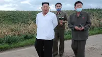 Dalam gambar tak bertanggal yang dirilis 28 Agustus 2020 memperlihatkan pemimpin Korea Utara, Kim Jong-un (kiri) mengunjungi daerah yang dilanda topan di Provinsi Hwanghae Selatan. Kunjungan Kim dilakukan usai televisi pemerintah KCTV menayangkan adegan kerusakan akibat topan. (STR/AFP/KCNA VIA KNS)