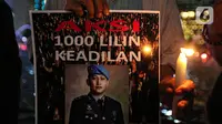 Massa aksi yang tergabung dalam Tim Advokat Penegak Hukum dan Keadilan (Tampak) menunjukkan poster bergambar Brigadir Yosua Hutabarat atau Brigadir J saat aksi 1000 lilin atas kematiannya di Bundaran HI, Jakarta, Jumat (22/7/2022). Aksi tersebut sebagai bentuk keadilan terkait kematian Brigadir J yang diduga akibat penyiksaan. (Liputan6.com/Faizal Fanani)