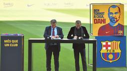 Bek baru Barcelona Dani Alves (kanan) dan presiden Barcelona Joan Laporta menandatangani kontrak pemain, selama upacara presentasi di stadion Camp Nou di Barcelona (17/11/2021). (AFP/Pau Barrena)