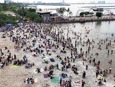 Foto udara memperlihatkan suasana Pantai Ancol Taman Impian, Jakarta, Selasa (1/4/2025) saat libur hari kedua perayaan Idul Fitri 1446 Hijriah. (Liputan6.com/Herman Zakharia)