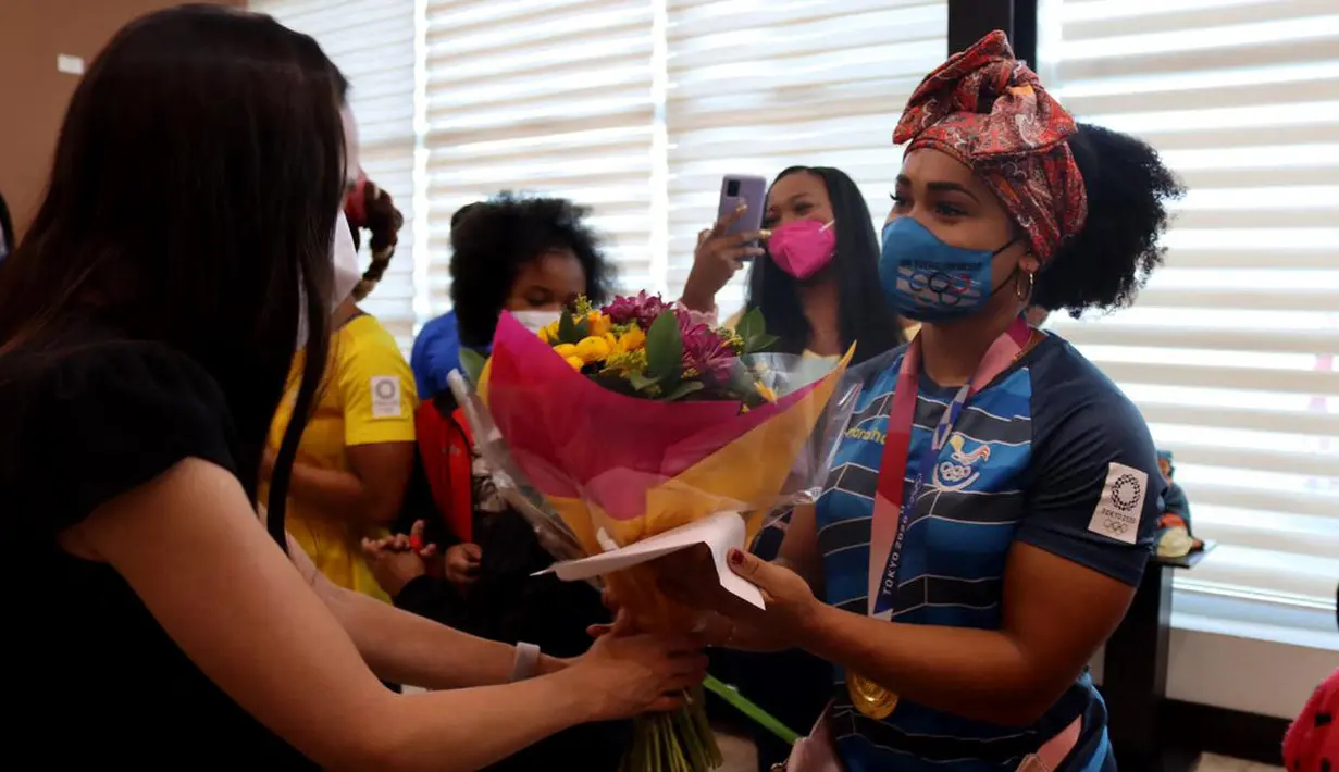 Lifter peraih medali emas, Neisi Patricia Dajomes Barrera menerima karangan bunga dari Kementerian Olahraga Ekuador setibanya di bandara Mariscal Sucre Quito (4/8/2021). (AFP/ Ecuador's Ministry of Sports)