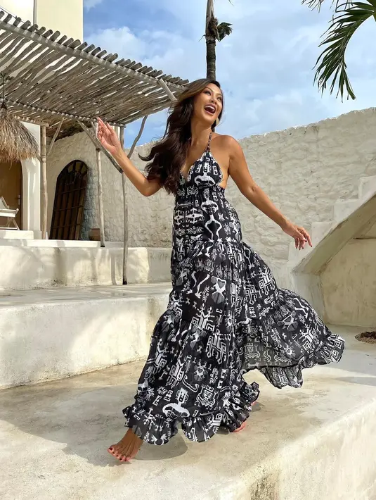 Masih dengan dress hitam putih, kali ini Indah Kalalo mengenakan dress dengan Sumba Print yang membuatnya terlihat etnik. Backless maxi dress dengan halter strap ini memiliki potongan bohemian. (Instagram/indahkalalo)