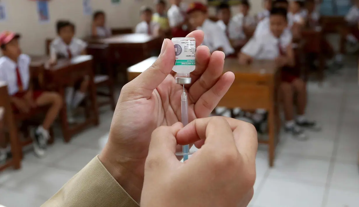 Seorang paramedis menyiapkan vaksin difteri untuk diberikan kepada siswa di sebuah sekolah dasar pada hari pertama sebuah kampanye di Tangerang, Senin (11/12). (AP Photo / Tatan Syuflana)