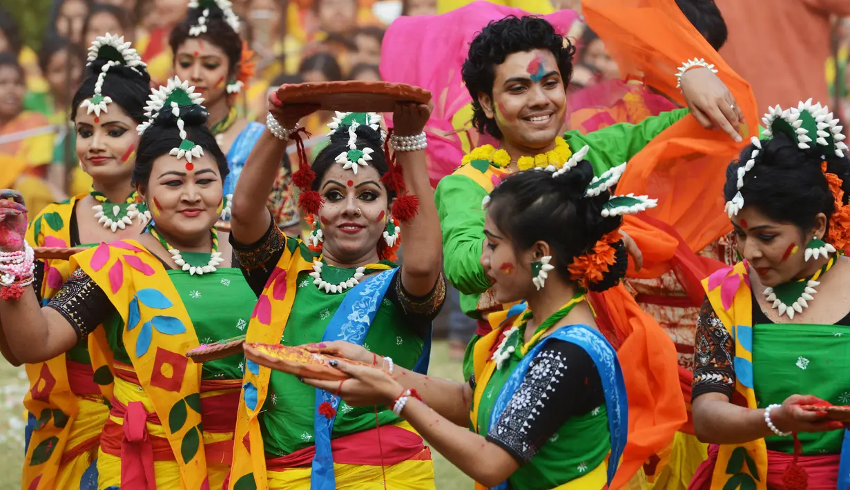 Sejumlah siswi menari selama perayaan Holi di Kolkata, India (7/3). Selama perayaan tersebut, peserta saling melemparkan bubuk berwarna-warni atau saling menyiramkan air berwarna-warni. (AFP/Dibyangshu)