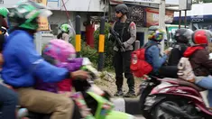 Polisi bersenjata laras panjang berjaga di jalur pantura Jalan Jenderal Ahmad Yani, Bypass, Kota Cirebon, Kamis (22/6). Pasukan bersenjata lengkap diterjunkan untuk mengantisipasi gangguan keamanan selama arus mudik Lebaran.  (Liputan6.com/Johan Tallo)