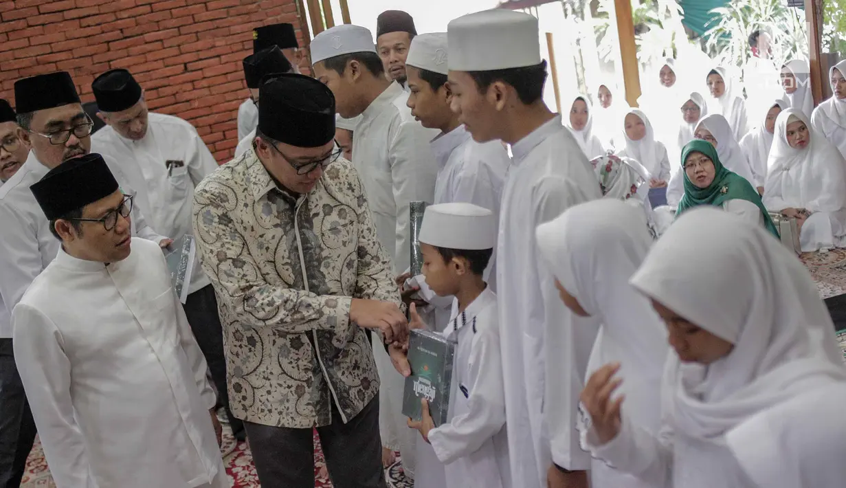 Menpora Imam Nahrawi bersalaman dengan anak-anak saat menghadiri pembukaan Nusantara Bertauhid di Ciganjur, Jakarta, Kamis (14/3). Kegiatan ini mengajak masyarakat berselawat dan mengkhatamkan Alquran. (Liputan6.com/Faizal Fanani)