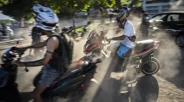 Orang-orang berkumpul di skuter listrik mereka untuk menghabiskan sore hari memamerkan aksi dan balap di Havana, Kuba, Jumat, 15 Juli 2022. Kuba telah dibanjiri dalam beberapa tahun terakhir dengan "motorinas", begitu skuter listrik ini disebut di pulau itu, sebuah mode bagi banyak orang, tetapi juga solusi untuk masalah transportasi dan kekurangan bahan bakar yang melanda negara Karibia itu. (AP Photo/Ramon Espinosa)