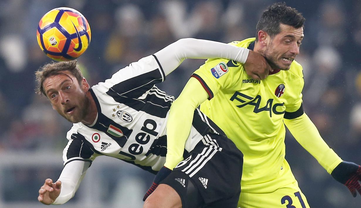 Duel pemain Juventus, Claudio Marchisio (kiri) dengan pemain Bologna, Blerim Dzemaili pada laga Serie A di Juventus Stadium, Turin, (8/1/2017). Juventus menang 3-0. (AFP/Marco Bertorello)