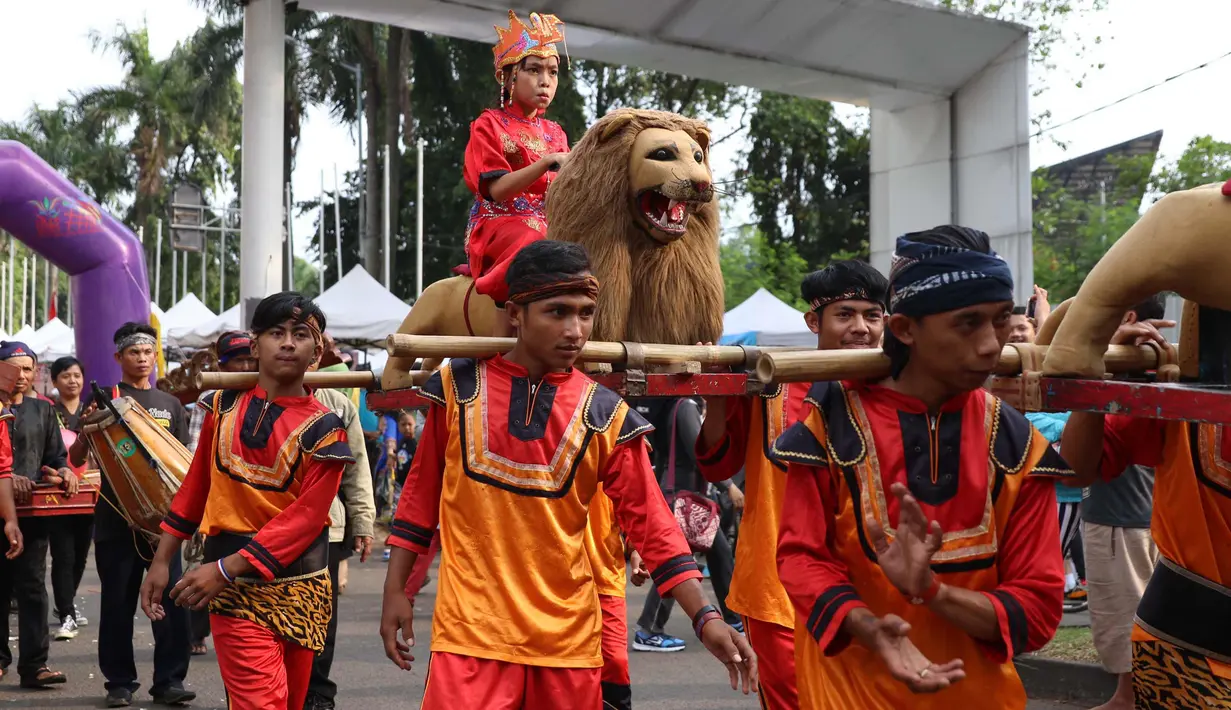 Warga menampilkan tarian Sisingaan Subang saat melakukan karnaval di jalan Pintu 1 Senayan, Jakarta, Minggu (24/9). Karnaval tersebut dilakukan dalam rangka HUT Gelora Bungkarno yang ke-55. (Liputan6.com/Angga Yuniar)