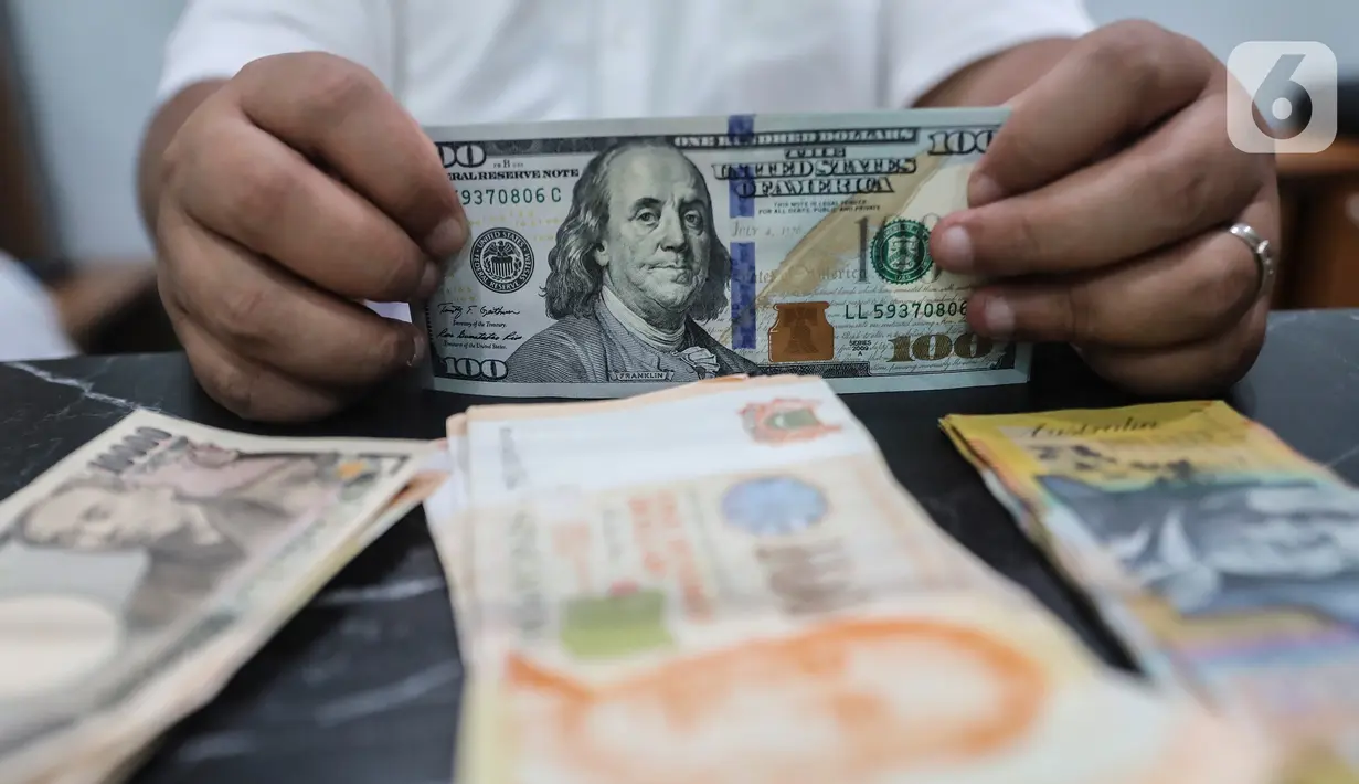 Petugas menghitung pecahan 100 dolar AS di jasa penukaran uang, Melawai, Jakarta, Rabu (28/9/2022). Nilai tukar rupiah tembus Rp15.236 per dolar AS pukul 10.41 WIB pada perdagangan Rabu (28/9/2022). (Liputan6.com/Johan Tallo)