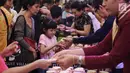 Seorang anak menerima kue bulan pada perayaan Festival Musim Gugur di Pluit Village, Jakarta, Sabtu (22/9). Festival Musim Gugur atau Festival Kue Bulan identik dengan pembagian kue bulan sebagai lambang kesejahteraan. (Liputan6.com/Herman Zakharia)