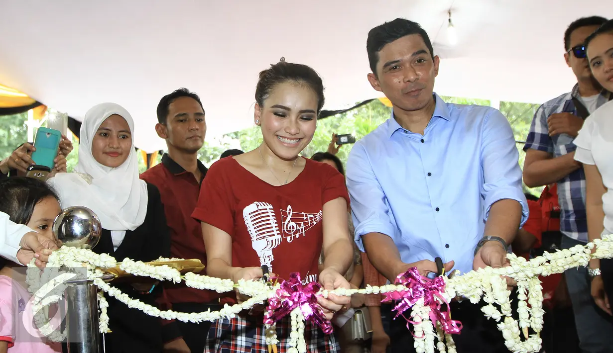 Penyanyi dangdut Ayu Ting Ting memotong pita tanda rumah karoke di buka di sela Press Conference Soft Opening Ayu Ting Ting Karaoke Keluarga di kawasan Kelapa Gading, Jakarta, Sabtu (19/3). (Liputan6.com/Herman Zakharia)