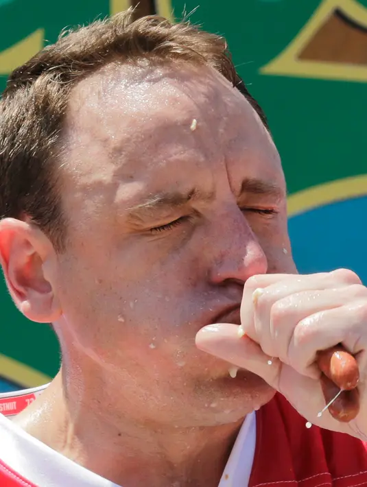 Ekspresi Joey Chestnut saat menyantap dua hot dog dalam Kontes Makan Internasional Nathan, di New York, AS (4/7). Joey Chestnut hanya kalah sekali dari Matt Stonie pada 2015. (AP Photo/Bebeto Matthews)