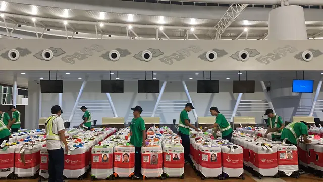 Koper jemaah calon haji Indonesia di Bandara Kertajati di Majalengka, Jawa Barat sedang dirapihkan petugas sebelum terbang menuju Madinah, Arab Saudi.