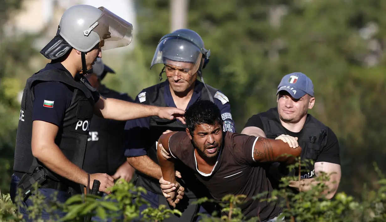 Salah satu warga pinggiran kota Roma, Stara Zagora, Bulgaria, diamankan petugas saat mencoba melawan pembongkaran tempat tinggalnya, (21/7/2014). (REUTERS/Stoyan Nenov)