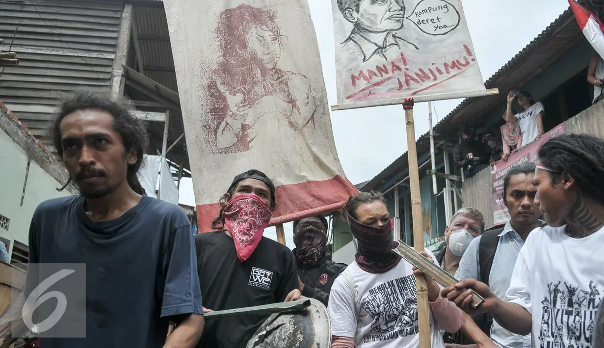 Sejumlah warga memukul kaleng dan panci saat Sanggar Saung Merdeka Ciliwung Bukit Duri digusur, Jakarta, Rabu (28/9). Padahal saat kampanye, Jokowi-Ahok berjanji tidak akan menggusur melainkan akan membangun kampung deret. (Liputan6.com/Yoppy Renato)