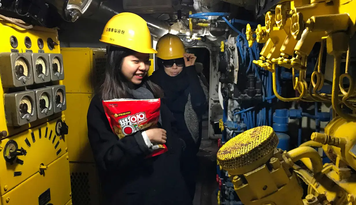 Pengunjung menaiki sebuah kapal selam Korea Utara yang dipamerkan di "Taman Unifikasi" tepi laut di Gangneung, Korea Selatan, (18/2). Kapal selam setinggi 35 meter ini kandas pada tahun 1996 saat misi spionase di daerah tersebut. (AP Photo/Johnson Lai)