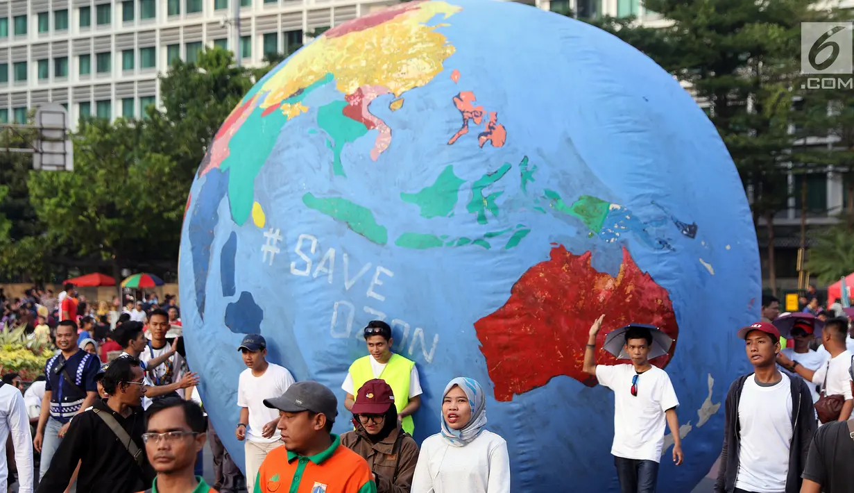 Replika bola dunia berukuran besar digelindingkan di sekitar kawasan Bundaran Hotel Indonesia, Jakarta, Minggu (16/9). Acara ini bagian dari peringatan Hari Ozon Sedunia yang jatuhnya setiap tanggal 16 September. (Liputan6.com/Helmi Fithriansyah)