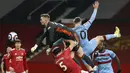 Kiper Manchester United, Dean Henderson memukul bola saat pekan 29 Liga Inggris 2020-2021 kontra West Ham di Old Trafford, Senin dinihari WIB (15/3/2021). Manchester United atau MU berhasil mencuri poin penuh usai kalahkan West Ham 1-0. (AP Photo/Clive Brunskill,Pool)