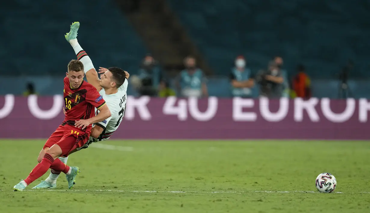 Gelandang timnas Belgia, Thorgan Hazard (kiri) berebut bola dengan bek Portugal, Diogo Dalot pada babak 16 besar Euro 2020 di Estadio La Cartuja, Sevilla, Spanyol, Senin (28/6/2021) dini hari WIB. Belgia mendepak juara bertahan Portugal berkat kemenangan 1-0. (THANASSIS STAVRAKIS / POOL / AFP)