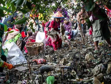 Anak-anak memungut sampah yang berserakan di sekitar kawasan pantai di Surabaya, Jawa Timur, Sabtu (21/9/2019).Aksi tersebut sebagai wujud kepedulian terhadap kebersihan lingkungan sekaligus dalam rangka memperingati World Cleanup Day 2019.  (JUNI KRISWANTO / AFP)