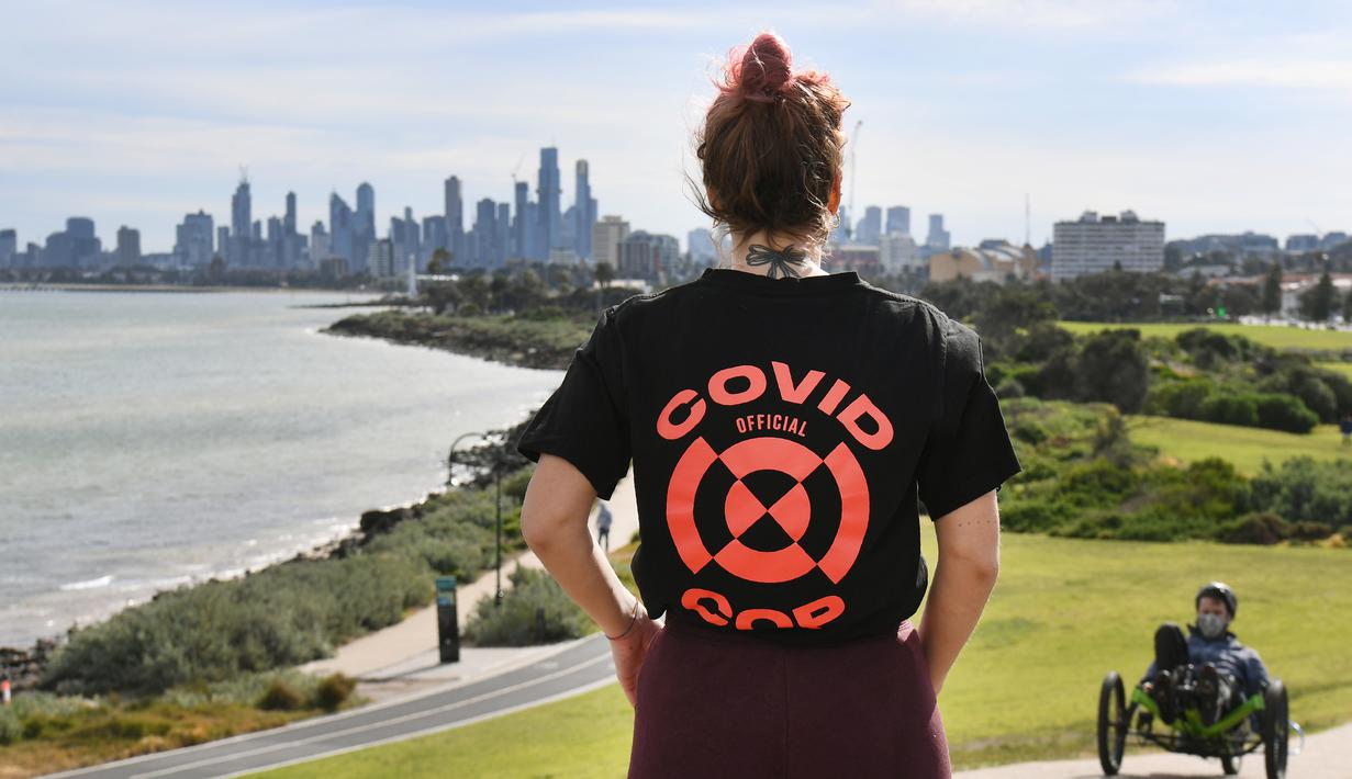 Seorang wanita melihat ke cakrawala Melbourne saat dia istirahat dari olahraga (11/8/2020). Negara bagian Victoria melaporkan 19 kematian akibat virus corona pada 11 Agustus, menjadikannya hari yang sama mematikan bagi pandemi di negara itu meskipun jumlah kasus baru turun. (AFP/William West)