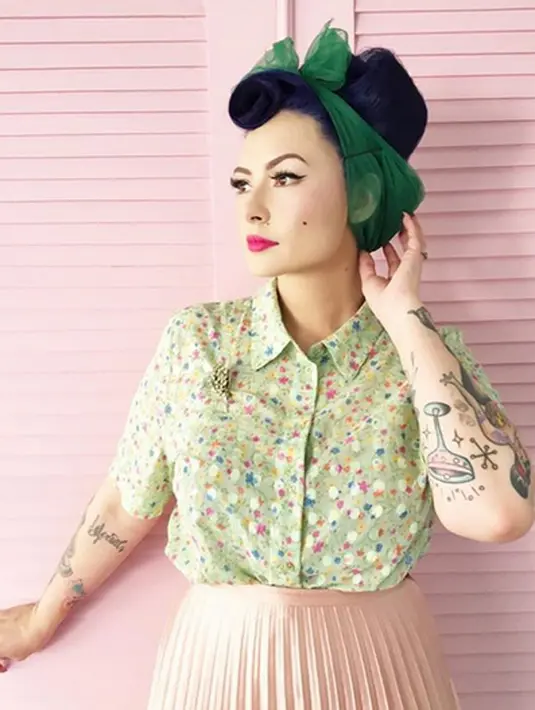 Masih dengan tampilan vintagenya. Kali ini Claudia menghias rambutnya yang dibuat sasak tinggi itu dengan kain hijau yang dibuat seperti pita. Ia pun mengenakan kemeja bermotif floral yang dipadukan rok berempelnya. (Instagram/miss_adinda_mae)