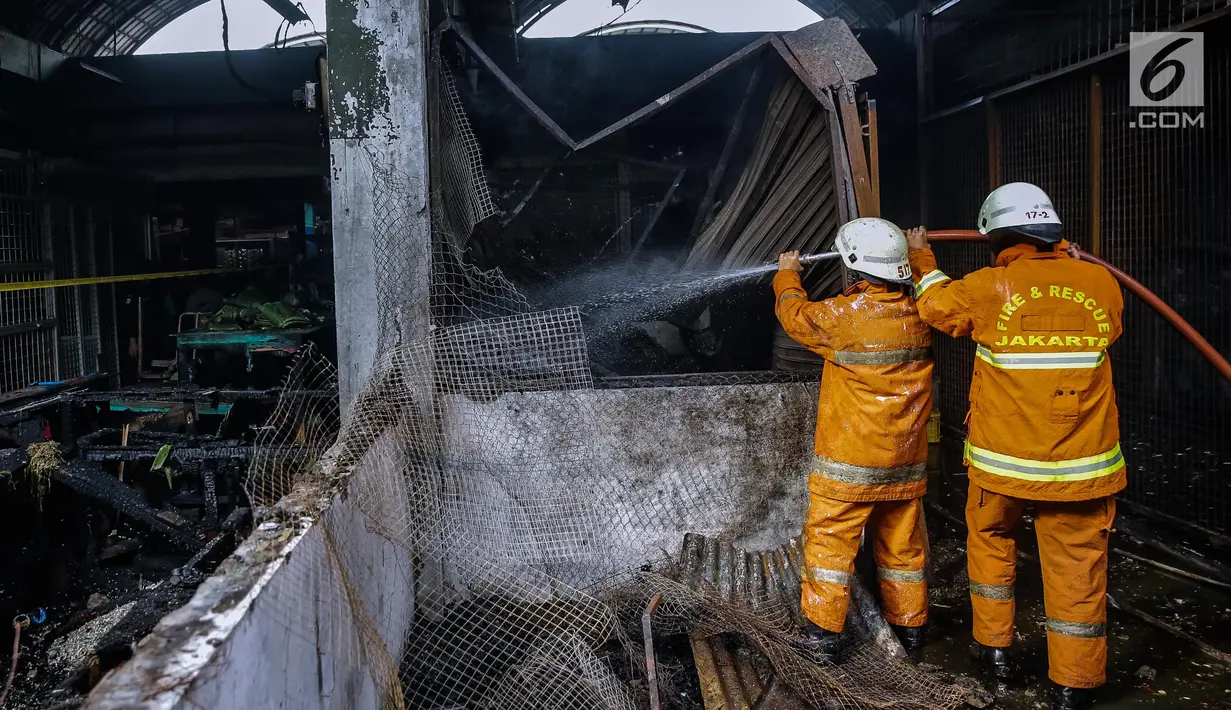 Petugas pemadam kebakaran melakukan pendinginan di lokasi Pasar Induk Kramat Jati Blok C1, Jakarta, yang terbakar, Senin (12/6). Sebanyak 90 kios di Blok C1 yang menjual beragam bumbu kering dan bumbu dapur hangus terbakar. (Liputan6.com/Faizal Fanani)