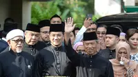 Muhyiddin Yassin (kedua kanan) melambaikan tangan sebelum upacara pelantikannya sebagai Perdana Menteri Malaysia di Istana Negara, Kuala Lumpur, Minggu (1/3/2020). Pelantikan dilakukan dengan alasan kursi kepemimpinan harus segera terisi. (NAZRI RAPAAI/AFP/MALAYSIA'S DEPARTMENT OF INFORMATION)