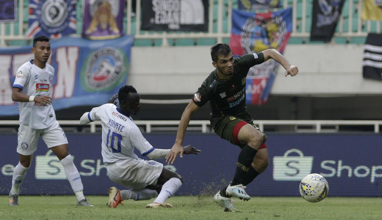Bek Tira Persikabo, Khurshed Beknazarov, berebut bola dengan gelandang Arema FC, Makan Konate, pada laga Shopee Liga 1 di Stadion Pakansari, Bogor, Kamis (24/10). Arema tahan  imbang 1-1 Tira Persikabo. (Bola.com/Yoppy Renato)