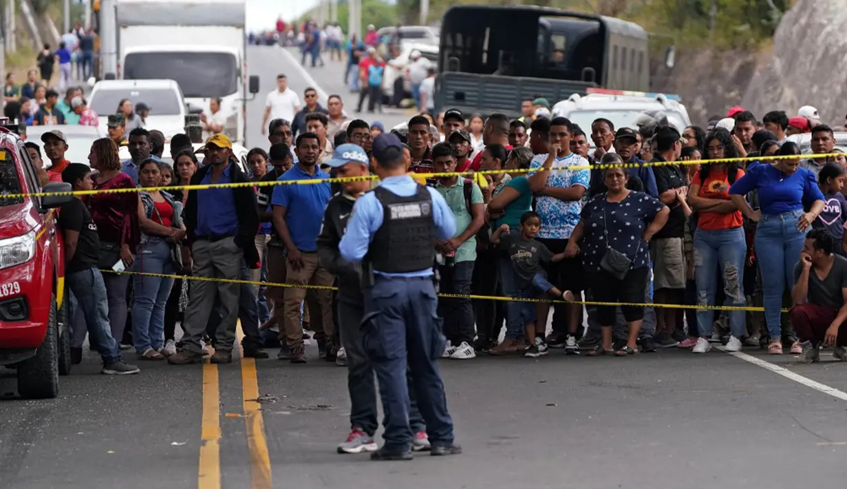 Warga menyaksikan upaya pemulihan setelah sebuah bus terjun ke sungai dangkal dekat Tegucigalpa. (Johny MAGALLANES/AFP)