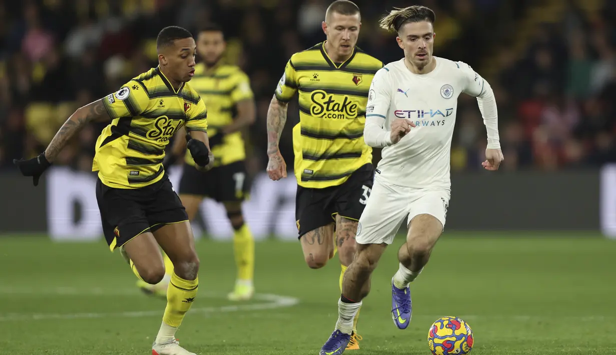 Gelandang Manchester City, Jack Grealish membawa bola dari kejaran pemain Watford, Joao Pedro pada pertandingan lanjutan Liga Inggris di Stadion Vicarage Road di Watford, Inggris (4/12/2021). Hasil ini mengantarkan Man City ke puncak klasemen Liga Inggris dengan 35 poin. (AP Photo/Ian Walton)