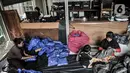 Pekerja melipat baju hazmat yang telah selesai dibuat di salah satu industri konveksi Pusat Industri Kecil (PIK), Jakarta, Rabu (30/12/2020). Baju hazmat dijual dengan harga Rp 65 ribu-Rp 195 ribu per buah, tergantung jenis bahan. (merdeka.com/Iqbal S. Nugroho)