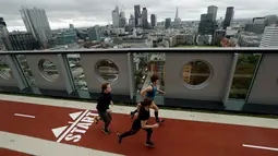 Pekerja berlari di sepanjang lintasan joging ketika peresmian  di atap gedung White Collar Factory, London, Selasa (5/9). Trek lari yang disebut-sebut tertinggi di London itu memiliki panjang lintasan 150 meter. (AP Photo/Matt Dunham)