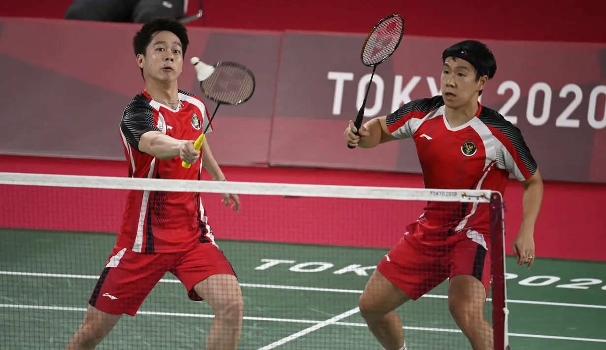 Ganda putra Indonesia Kevin Sanjaya Sukamuljo (kiri) dan Marcus Gideon melawan Ben Lane dan Sean Vendy dari Inggris pada pertandingan ganda putra Grup A Olimpiade Tokyo  2020 di Musashino Forest Sports Plaza, Sabtu (24/7/2021). Kevin / Marcus menang 21-15, 21-11. (Alexander NEMENOV/AFP)