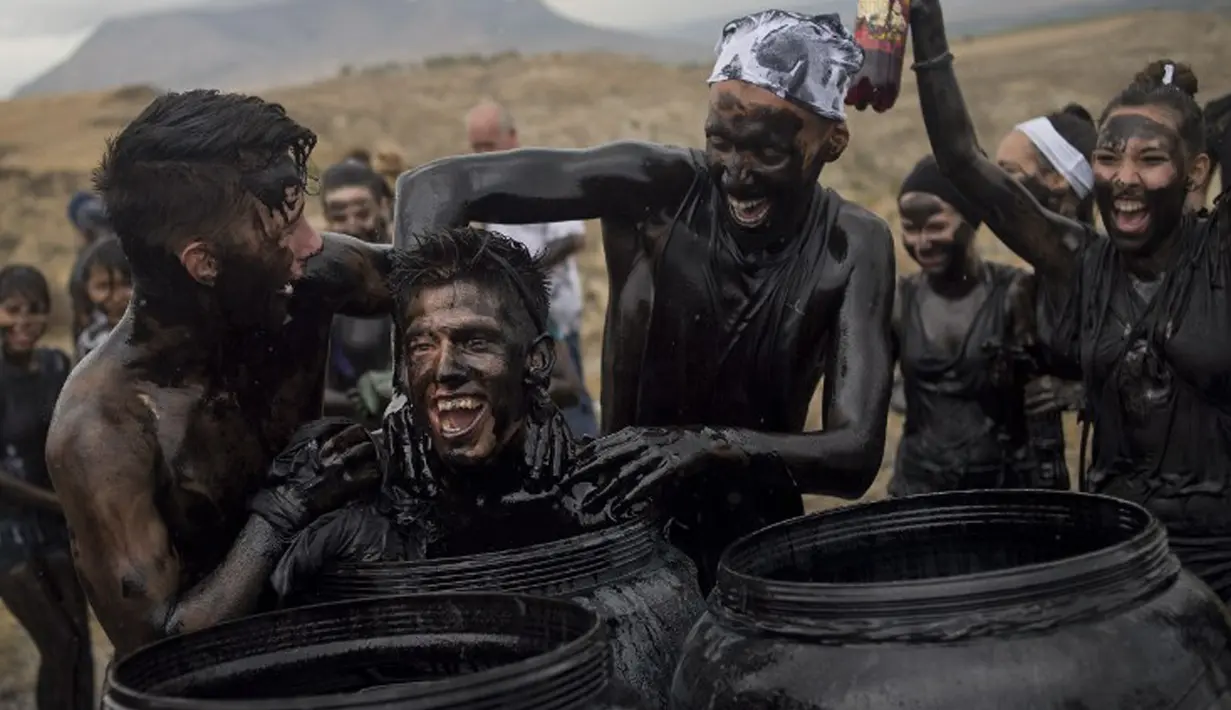 Peserta menyiramkan minyak dan cat hitam ke rekannya saat Festival Cascamorras di Baza, Spanyol, 6 September 2015. Festival ini diadakan setiap 6 September tiap tahunnya dan telah dilakukan selama 500 tahun terakhir. (AFP PHOTO/JORGE GUERRERO)