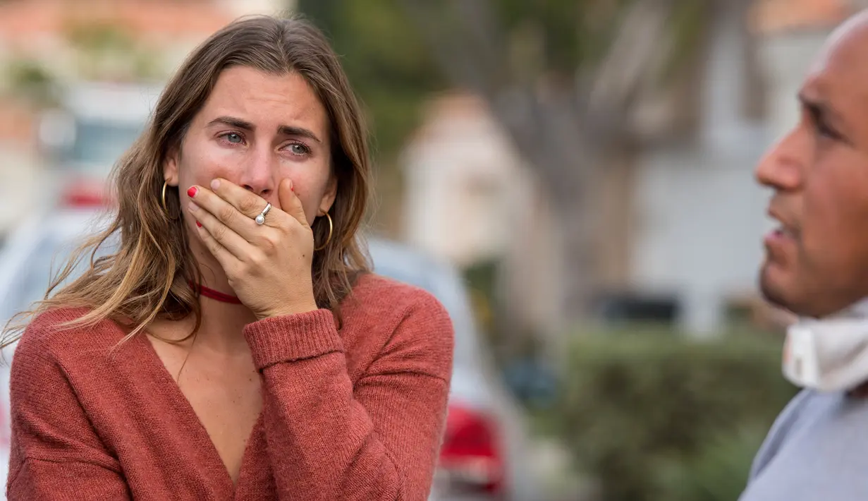 Seorang kerabat menangis saat mendengar keterangan jatuhnya helikopter di lingkungan perumahan, Newport Beach, California, Selasa (30/1). Petugas berwenang belum mengetahui penyebab helikopter itu jatuh. (Leonard Ortiz/The Orange County Register via AP)