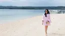 Masih berada di tepi pantai, Tistha tampil dengan mini dress berwarna pink yang berlengan panjang. Tanpa memakai alas kaki, Tistha yang berada di panas terik memakai sun glasses saat berjalan di pasir pantai. (Instagram/tisthanurma)