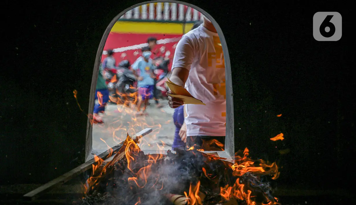 Warga Tionghoa kertas sembahyang saat perayaan Tahun Baru Imlek 2573 Kongzili di Vihara Avalokitesvara, Tangerang Selatan, Selasa (1/2/2022). Pengelola Vihara memberlakukan pengaturan waktu dan jumlah pengunjung  dengan ketentuan protokol kesehatan Covid-19 yang berlaku. (Liputan6.com/Faizal Fanani)