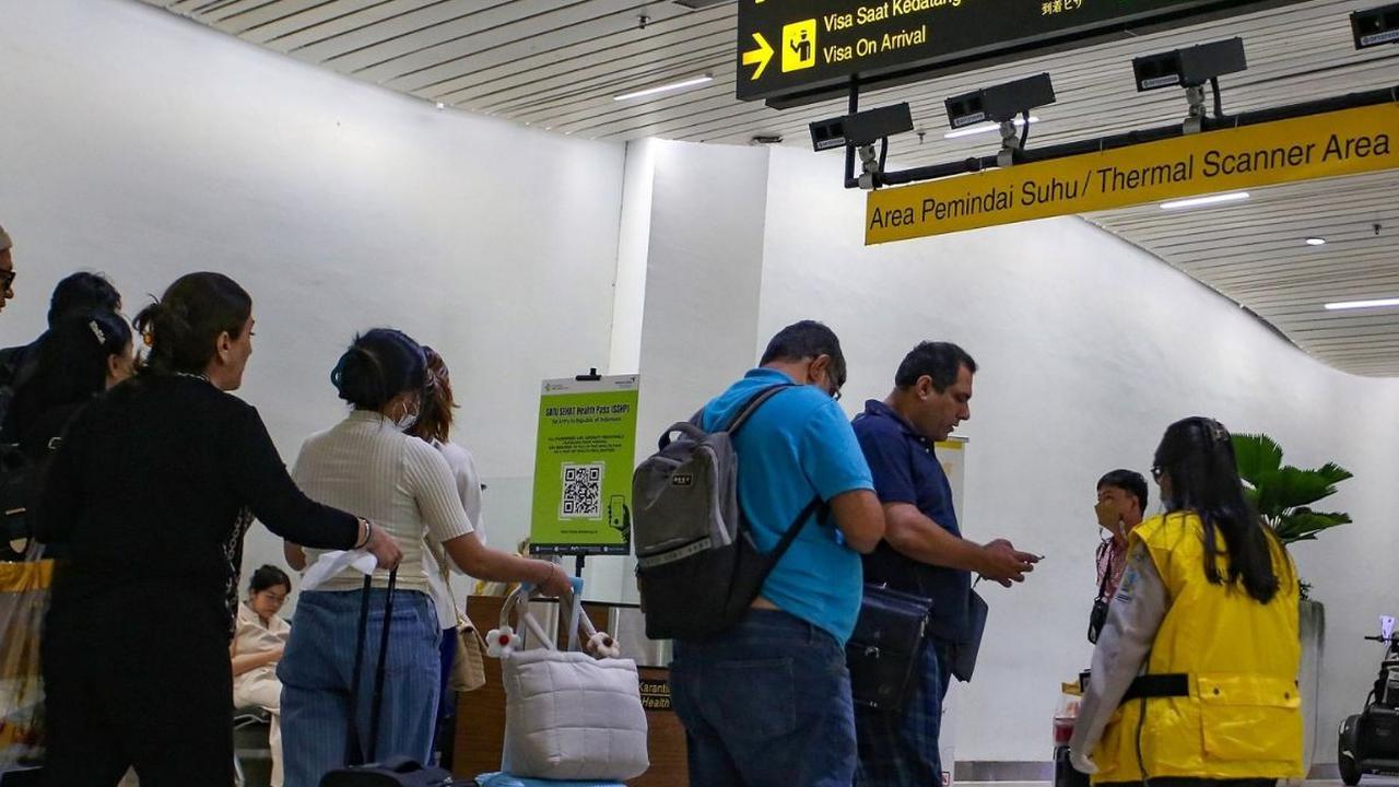 Penumpang dari luar negeri yang tiba di Terminal 3 Internasional Bandara Soekarno-Hatta, Rabu (11/9/2024), menjalani pemeriksaan ketat di area pemindai suhu tubuh milik Balai Besar Kekarantinaan Kesehatan (BBKK) Soekarno-Hatta. Foto: merdeka.com / Arie B